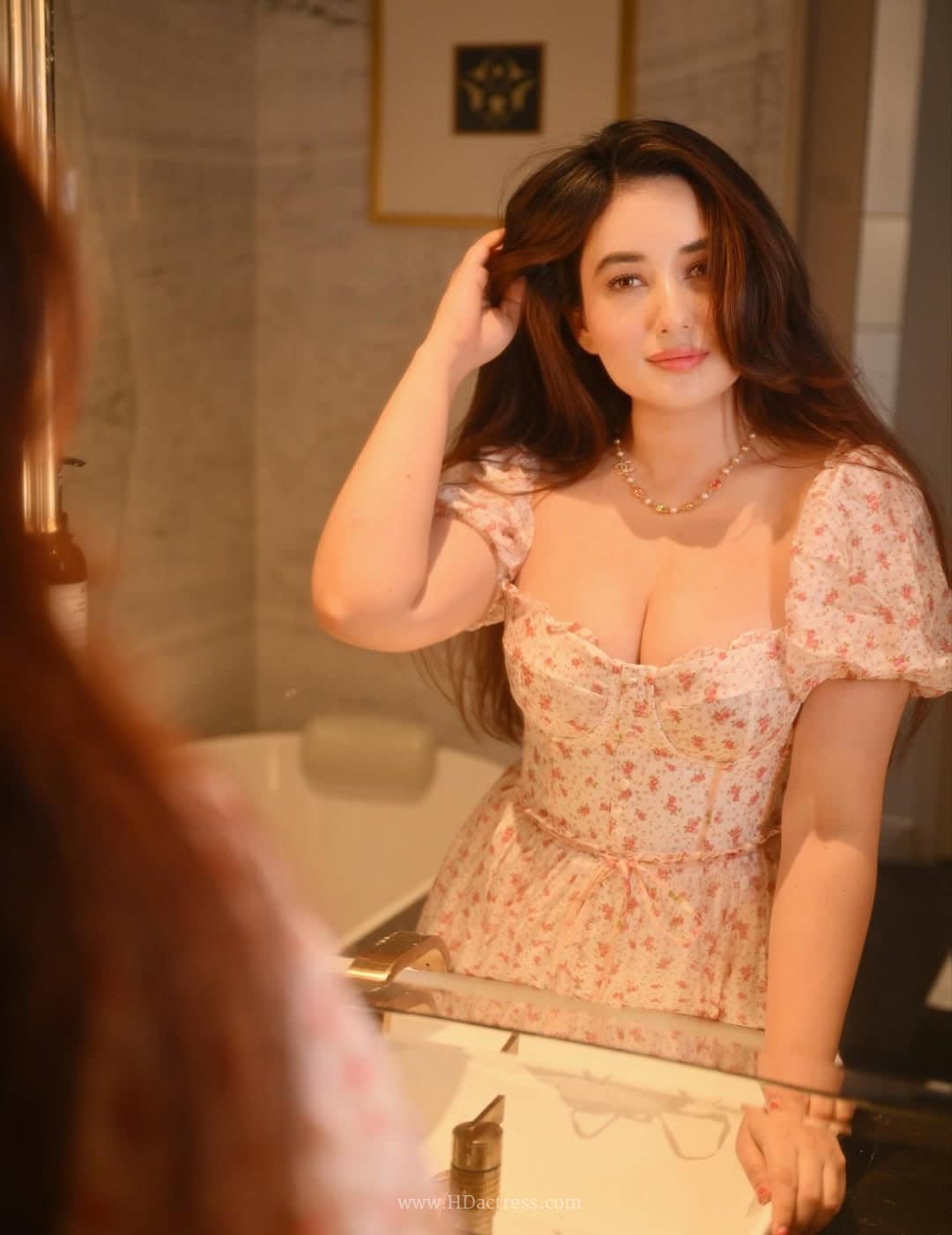 Aditi Budhathoki looking glamorous in a red and white gingham outfit with a sweetheart neckline and dramatic short sleeves.