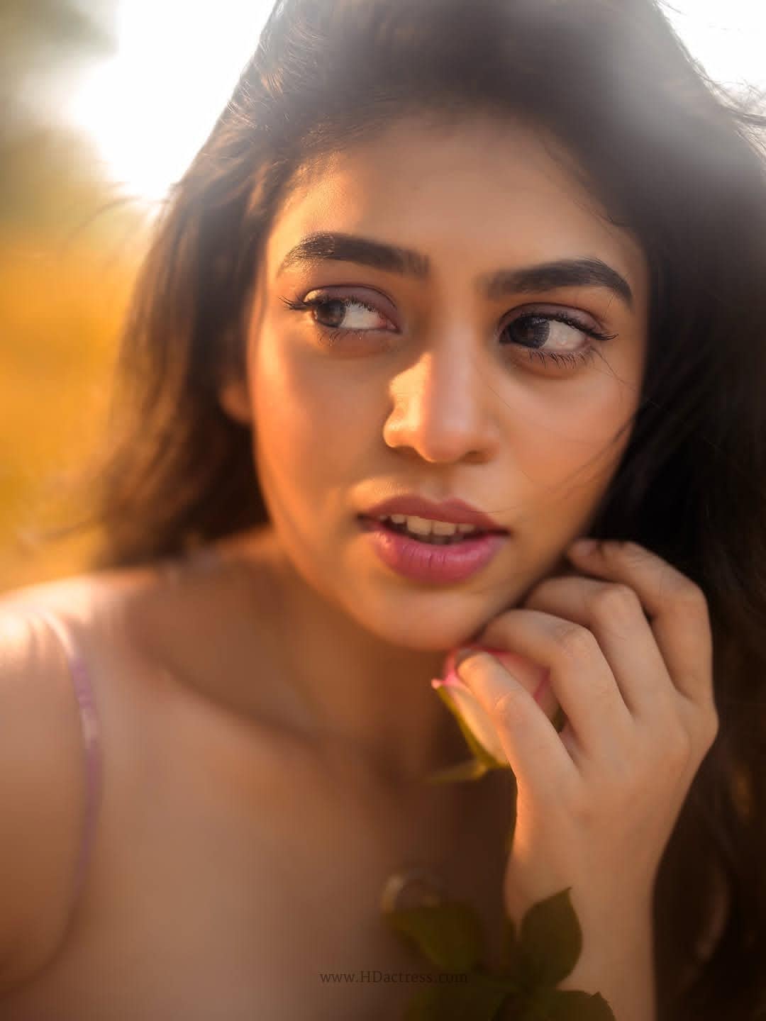 Actress Bandhavi Sridhar posing in a glamorous close-up portrait highlighting her sharp facial features