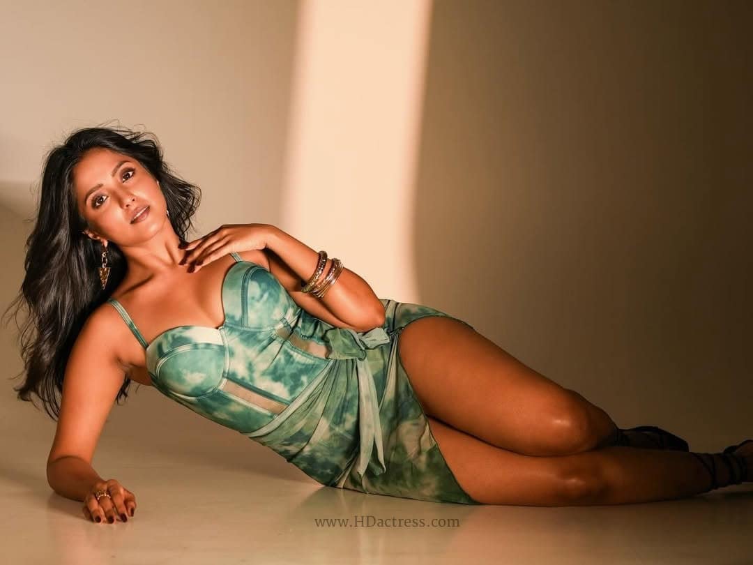 Actress Ulka Gupta posing confidently in a short black sweetheart neckline mini dress showing off her legs.