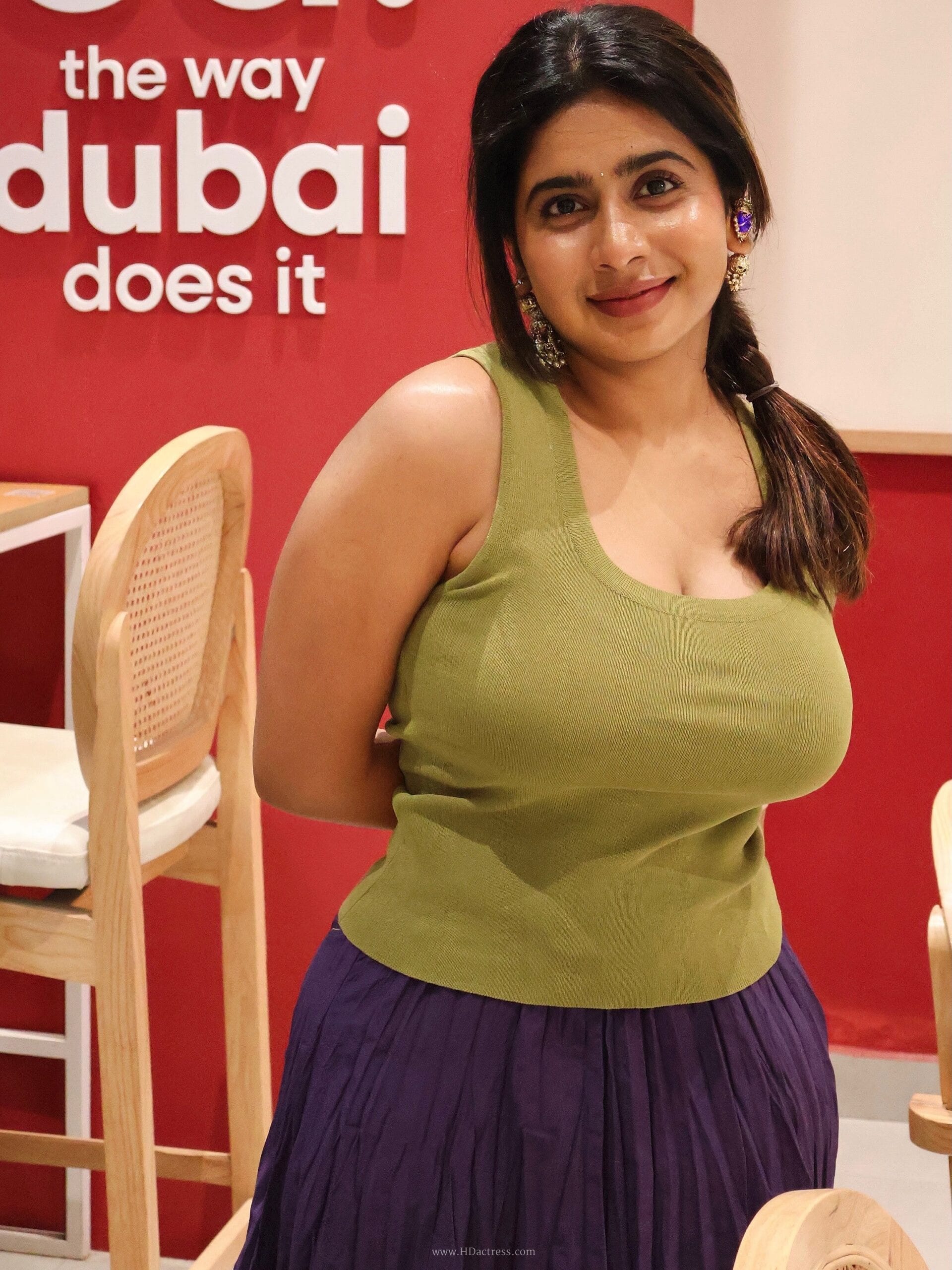 Close-up fashion portrait of Pratibha modeling a fitted white tank top against a bright background.