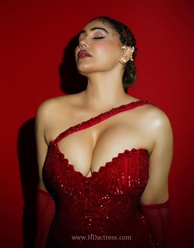 Wide shot of Kangana Sharma flaunting her hourglass figure in an elegant yet revealing red gown.