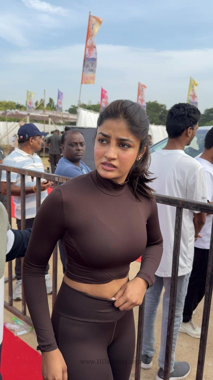 Dimple Hayathi posing confidently in a tight pink tank top and floral gym leggings during her Yoga Day session.