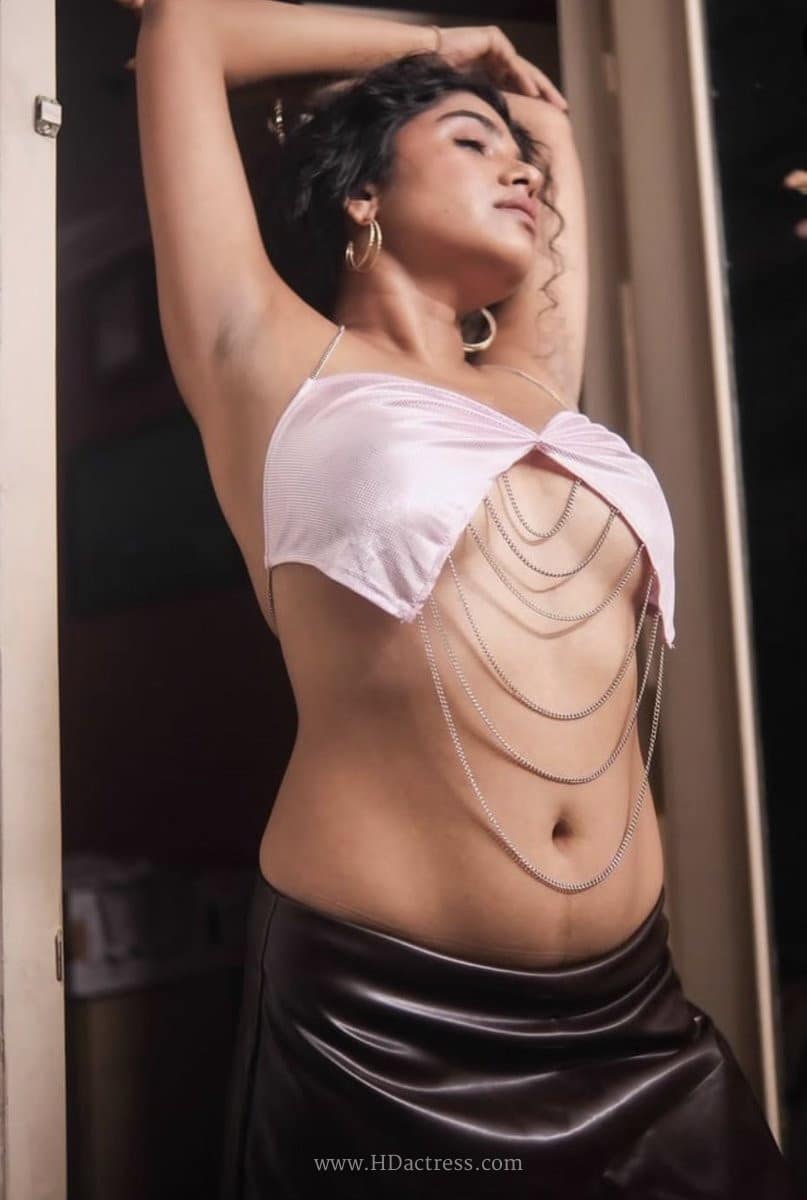Gayathri Ajith posing in a metallic pink satin halter crop top featuring an underbust design and body chains.